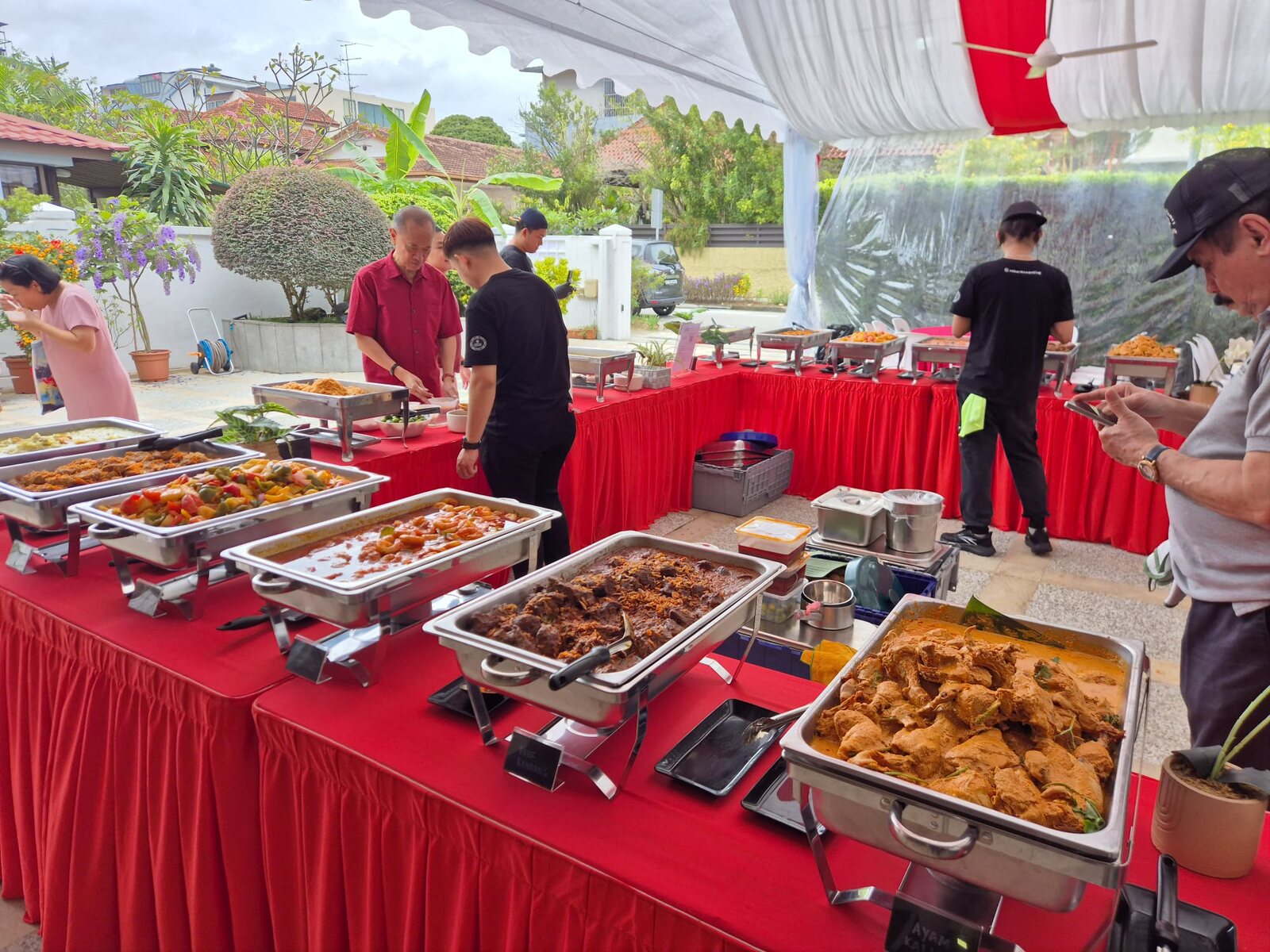 A Sabar Menanti catering set-up under a tent at a family event